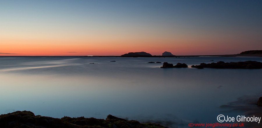 Sunrise at Yellowcraigs Beach. Two hours before dawn. The Bass Rock in distance with lighthouse light showing.