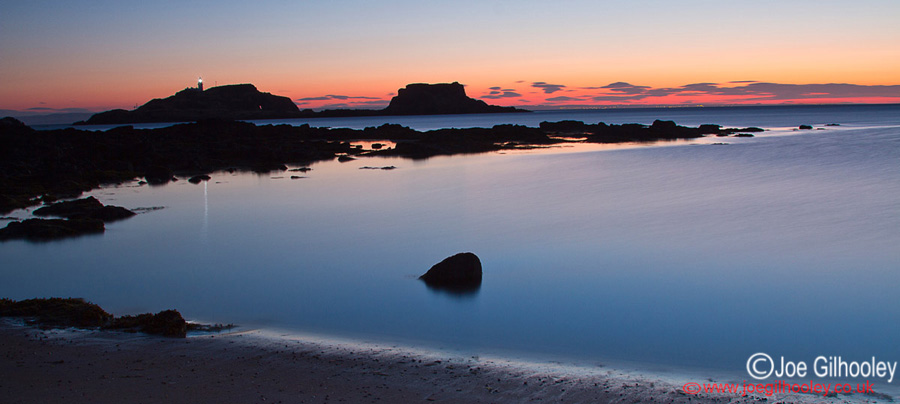 Sunrise at Yellowcraigs Beach. Two hours before dawn. Fidra Island with lighthouse light showing. Getting reflections from lighthouse light.