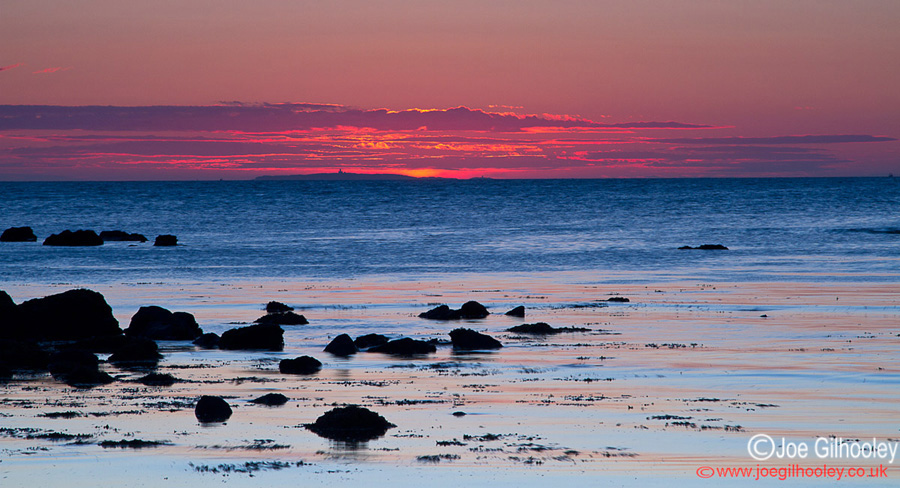 Sunrise at Yellowcraigs Beach. Sky changing in those pre dawn minutes. Isle of May appearing in sunrise on horizon.